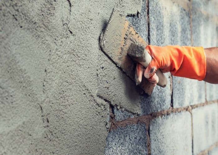 Plastering work being completed on a wall